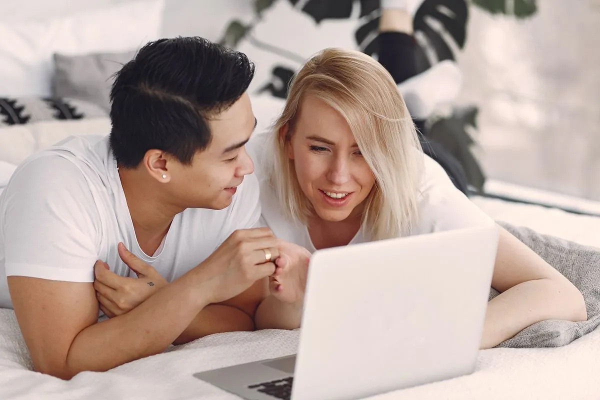 Couple approved for a $2,000 loan reviewing offers on a laptop
