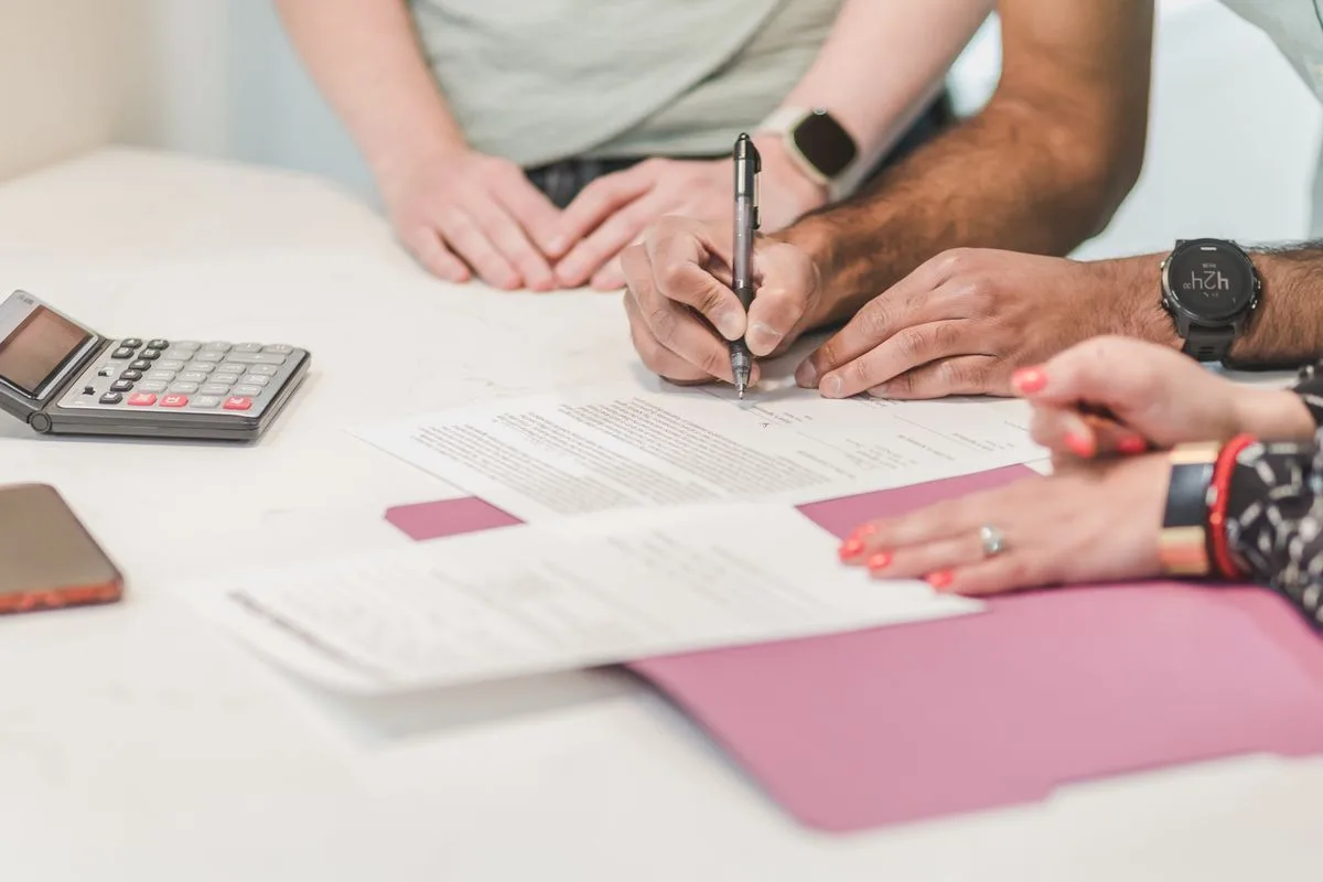 Applying for a $5,000 loan in Canada with a calculator and signed agreement