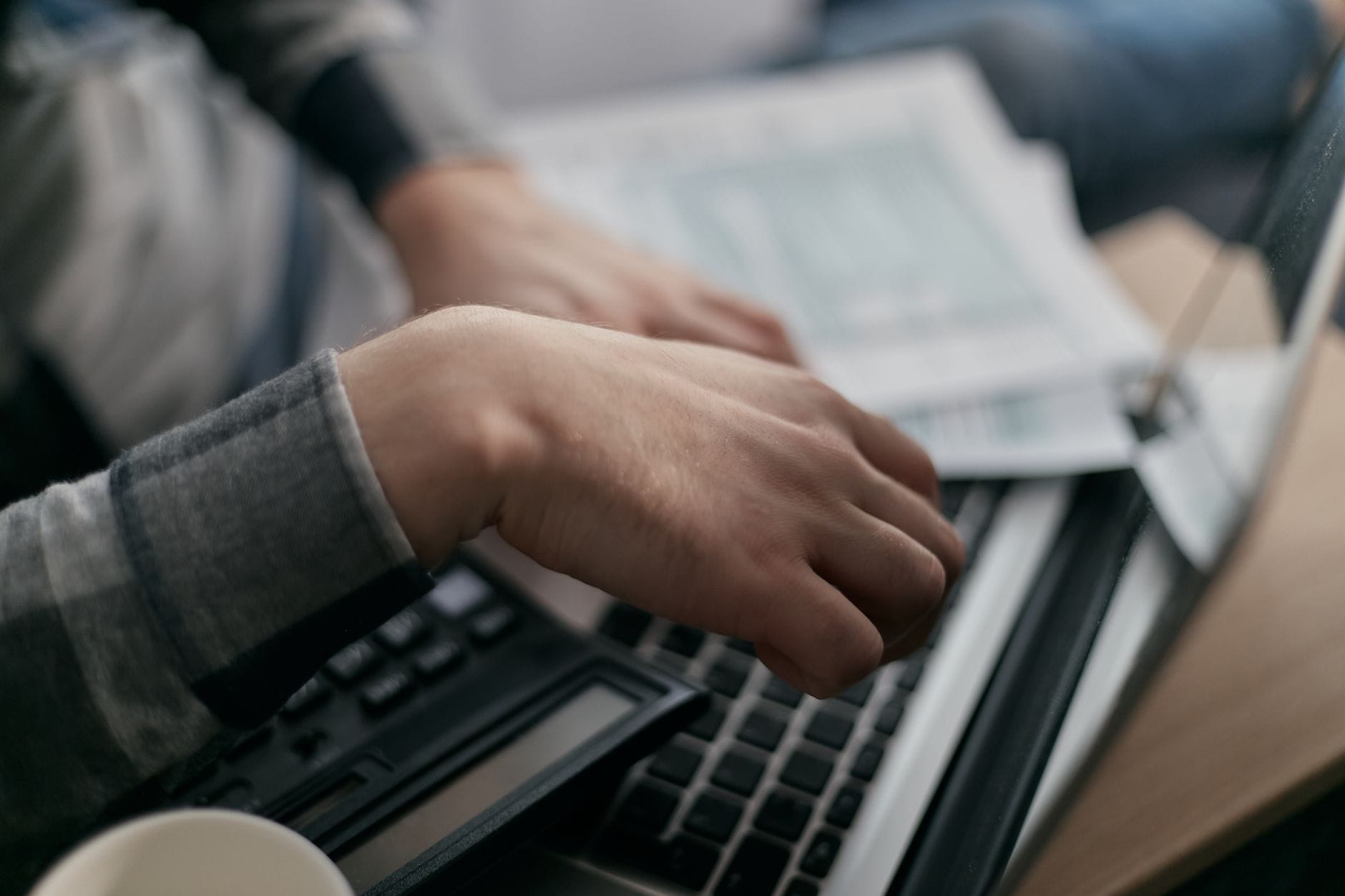Hands calculating finances with a laptop - personal loan as a cash advance alternative in Canada