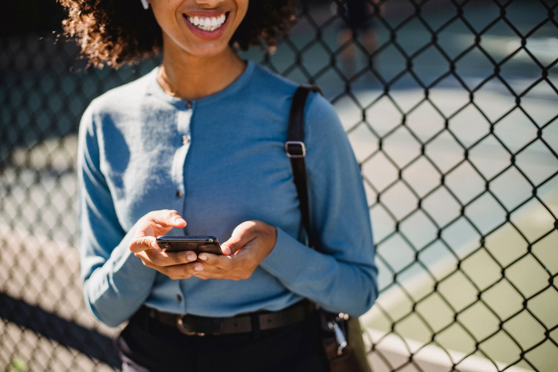 Personne souriante utilisant un téléphone — prêts par virement Interac au Canada