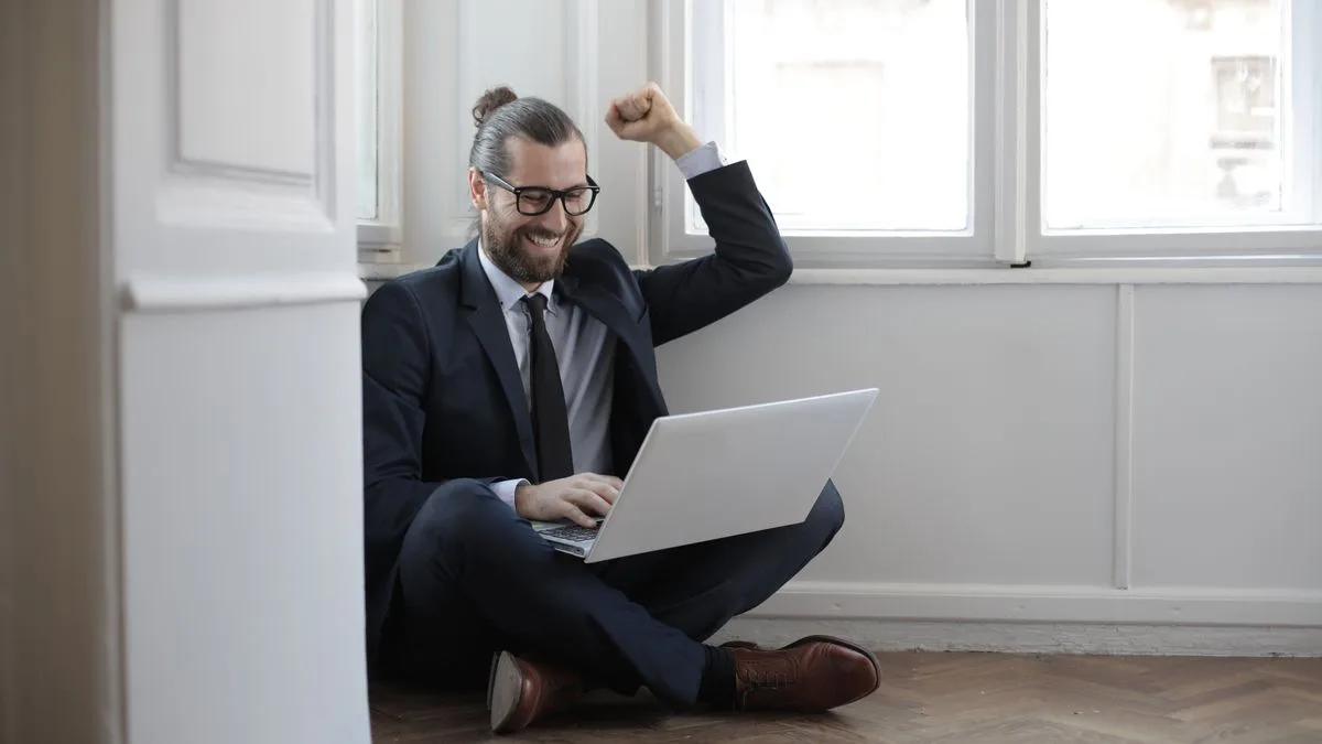 Borrower approved for a personal loan in Canada celebrating at his laptop