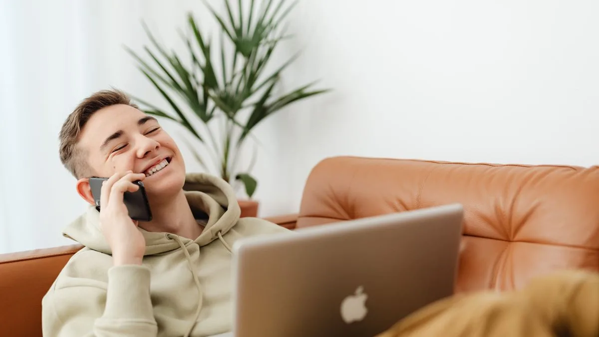 Man confirming his income during a personal loan application by phone and laptop