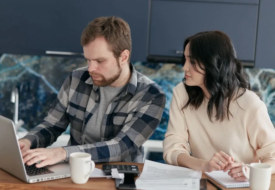 Canadian couple comparing personal loans for fair credit at home on a laptop