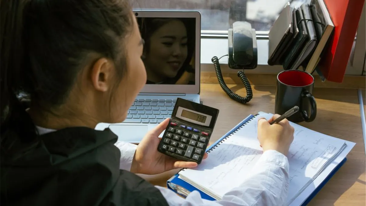Woman checking whether her personal loan is taxable income using a calculator
