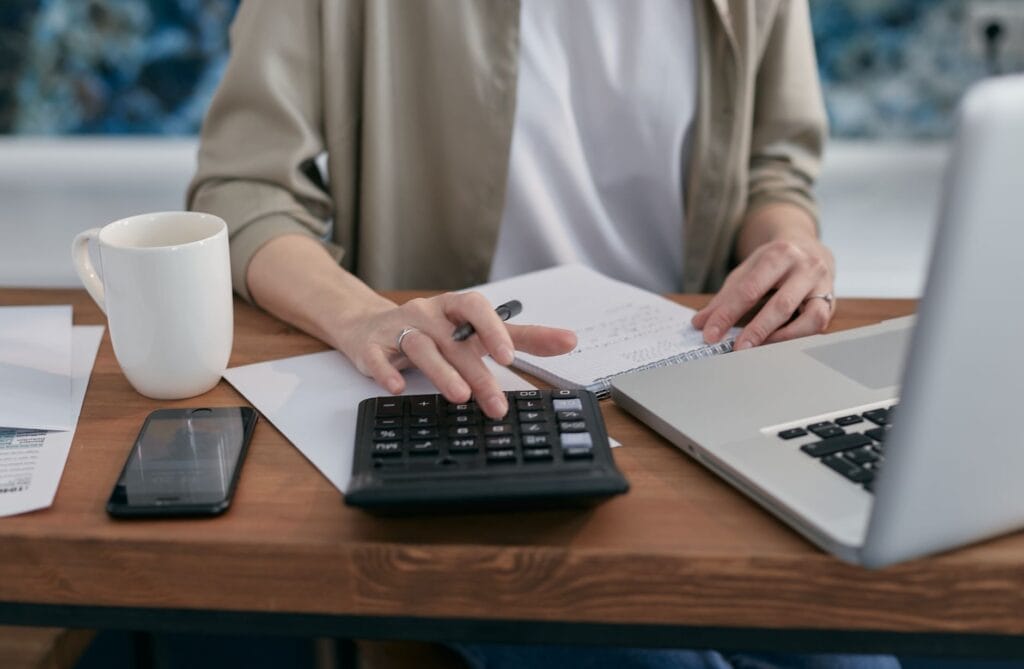 Organizing finances with a calculator and laptop - second chance loans in Canada