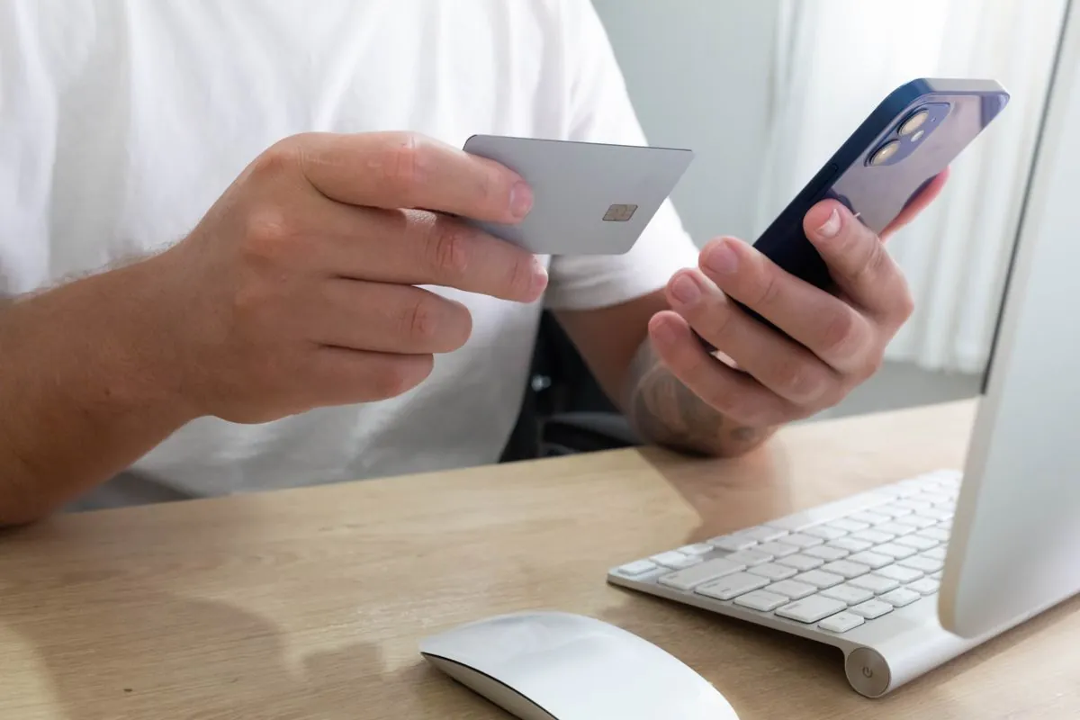 Applying online for a $1500 loan with a card and phone at a desk