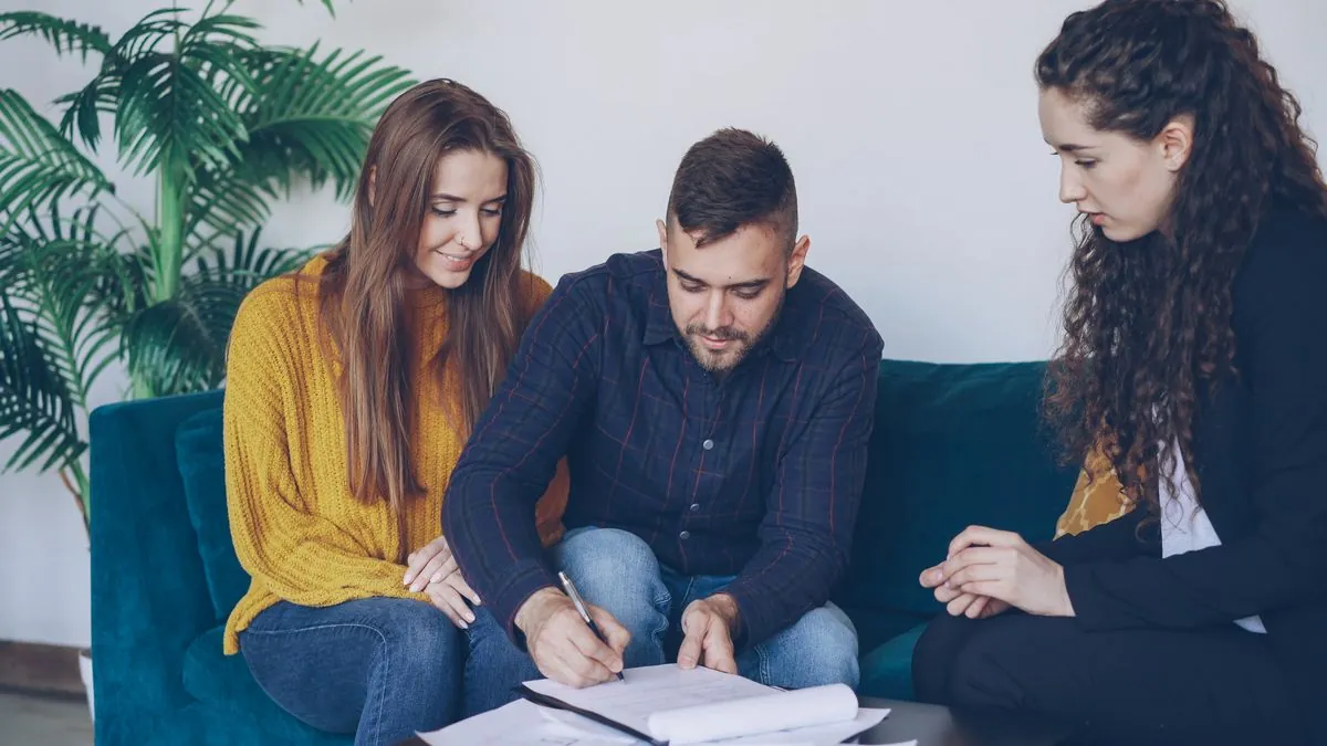 Couple approved for a $4000 loan signing the loan agreement