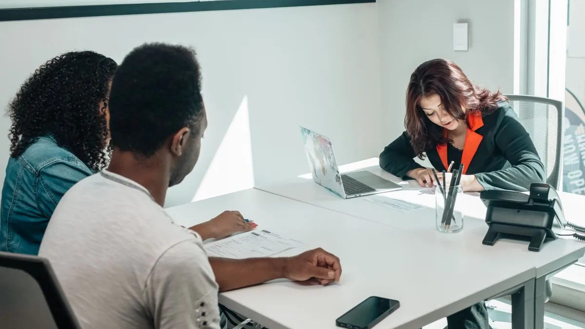 Couple comparing personal loan rates with an advisor in a bright office