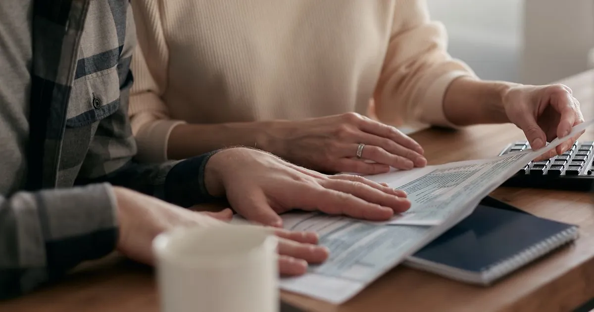BC couple comparing installment loan offers at home with a calculator and paperwork