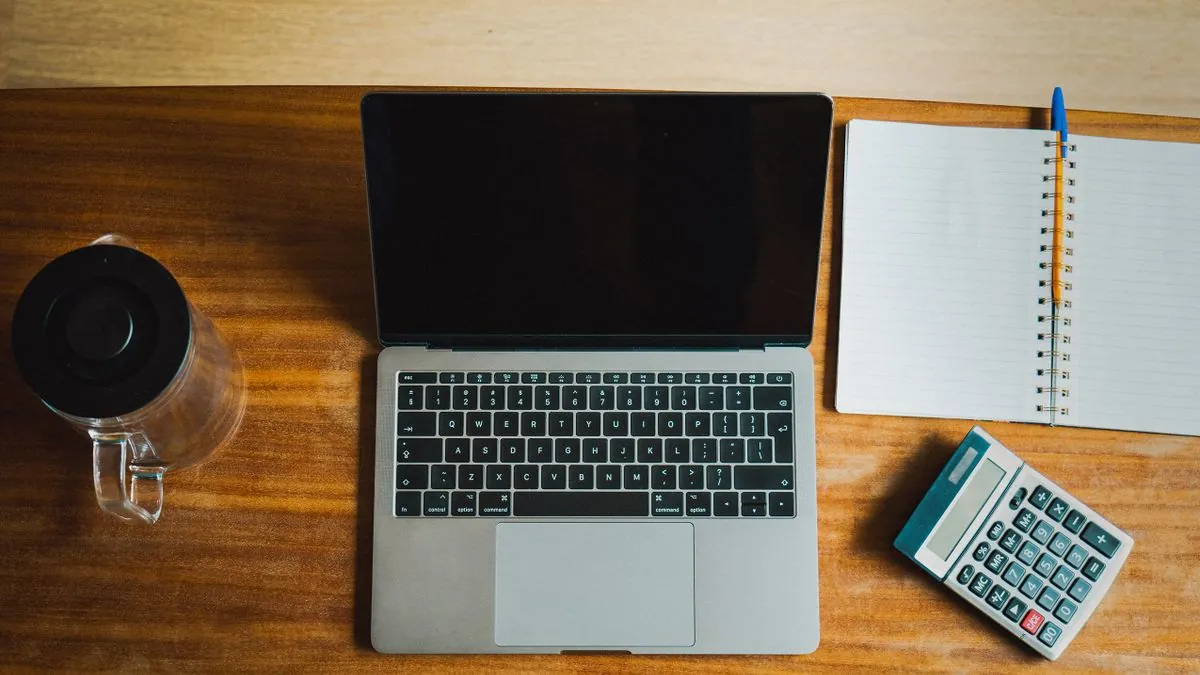 Desk with laptop, notebook and calculator for working out personal loan rates