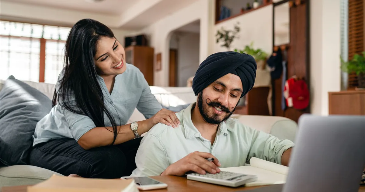 Couple comparing 600 loan Canada offers with a calculator and laptop at home