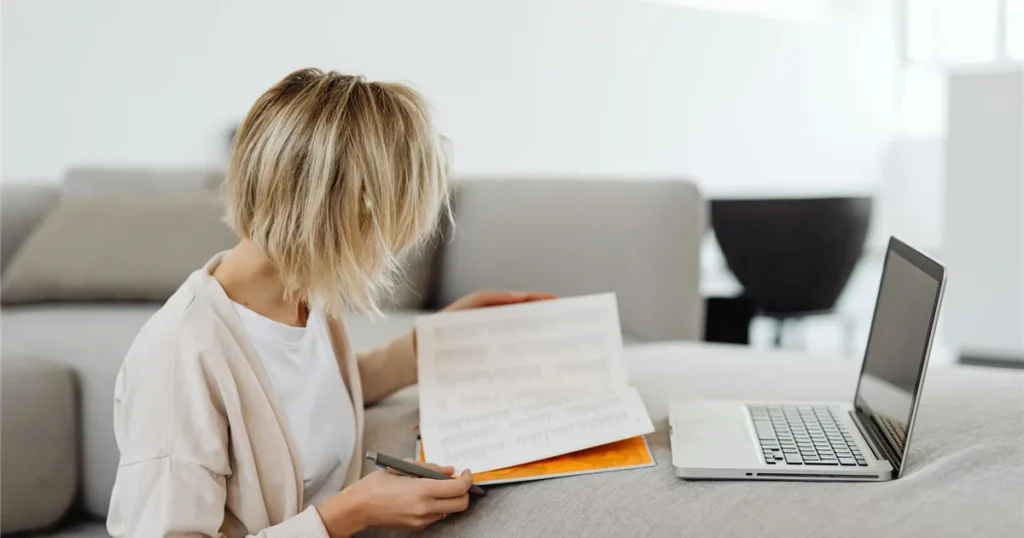 Woman reading loan terms beside her laptop - what is an installment loan in Canada