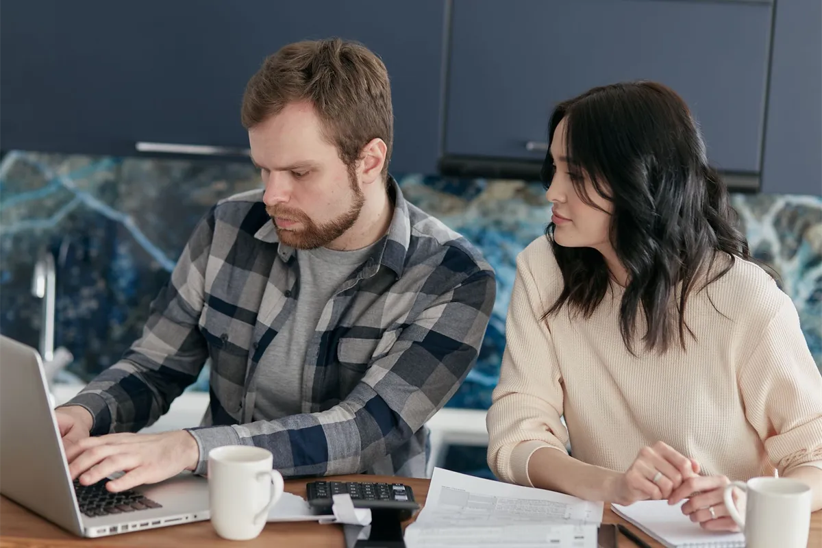 Couple planning the monthly payment on a $5000 loan with bad credit at their kitchen table