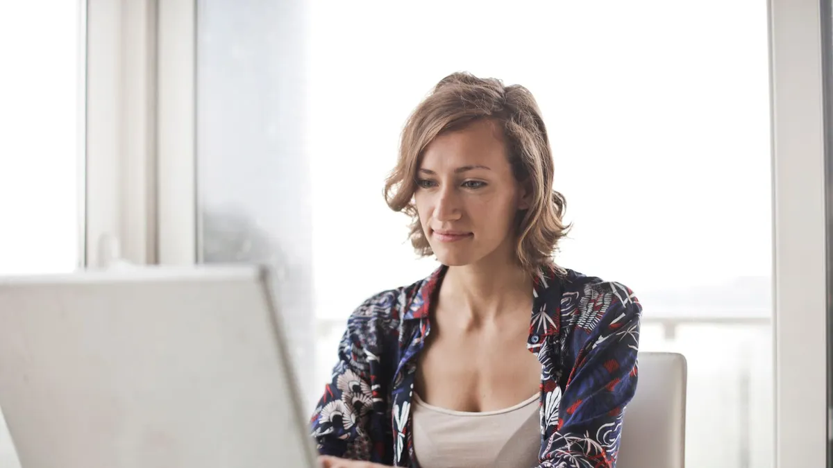 Woman comparing secured vs unsecured loans on her laptop at home