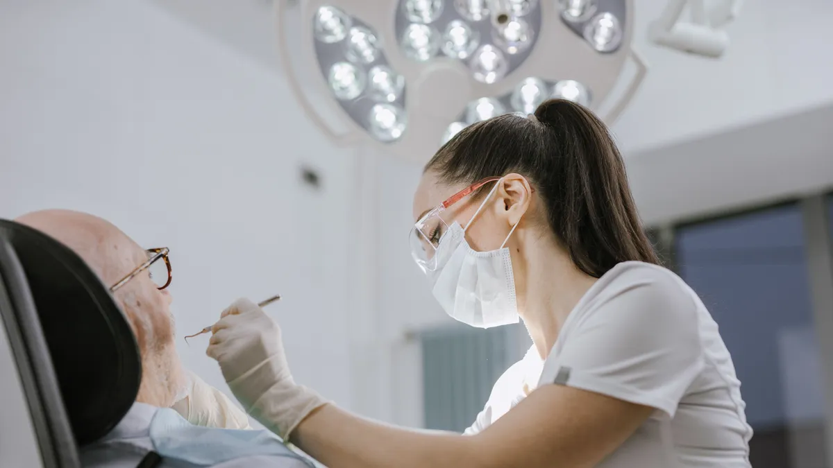 Dentist treating a patient in a clinic, a dental bill being one of the common reasons for a $2000 loan in Canada