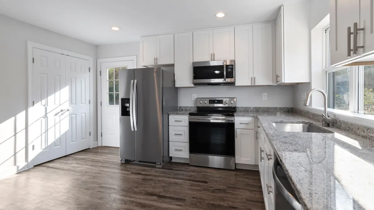 Bright kitchen with a stainless fridge and stove, the appliance replacement a $2000 loan is often taken for