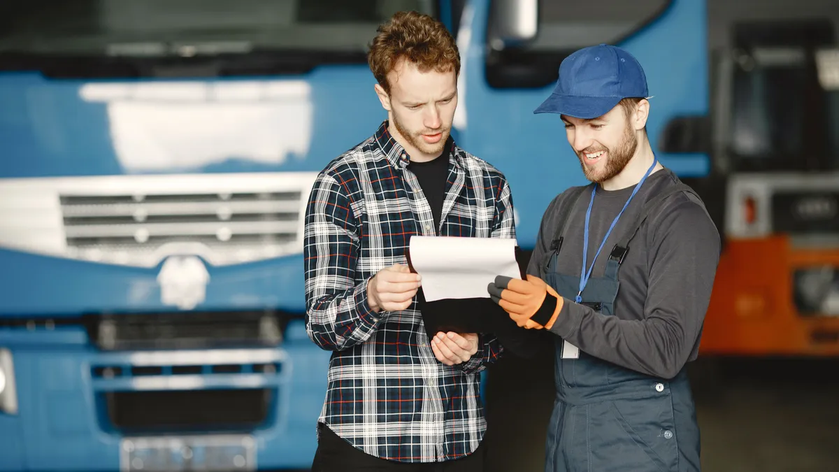 Mechanic going over a repair estimate with a customer, the kind of $2000 bill a personal loan covers