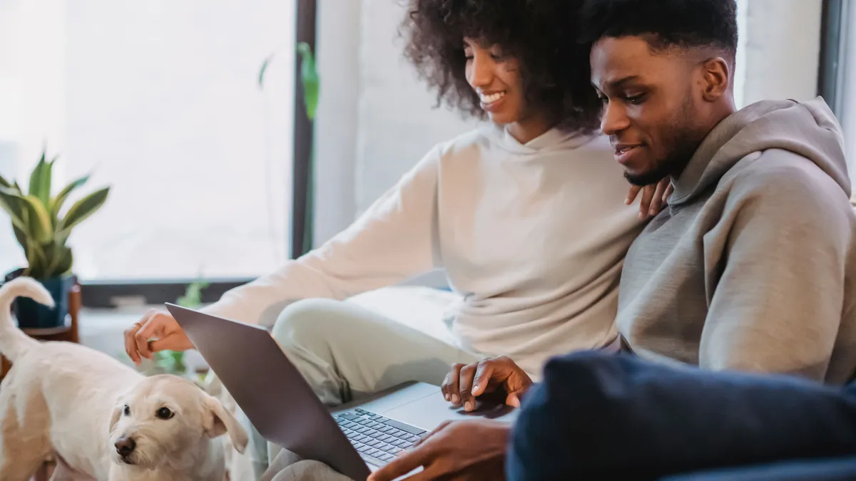 Couple at home checking personal loan rates on a laptop