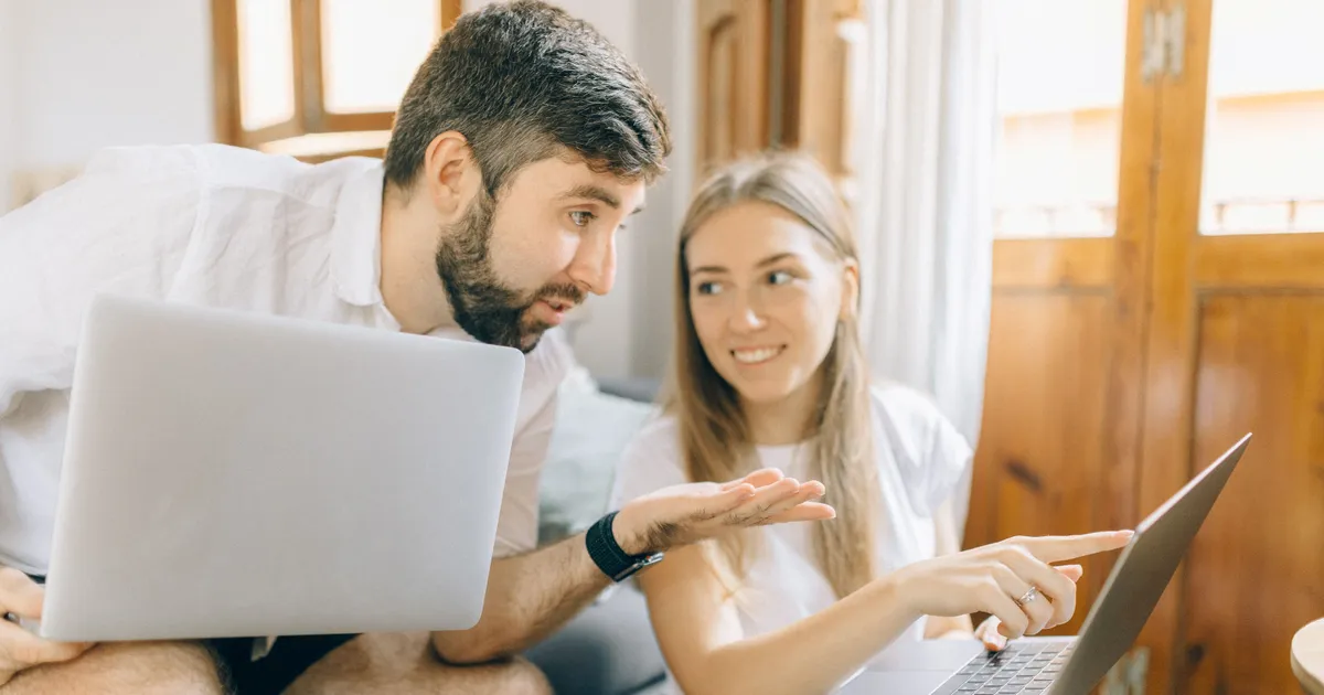 Couple comparing personal loan offers in Canada on two laptops at home