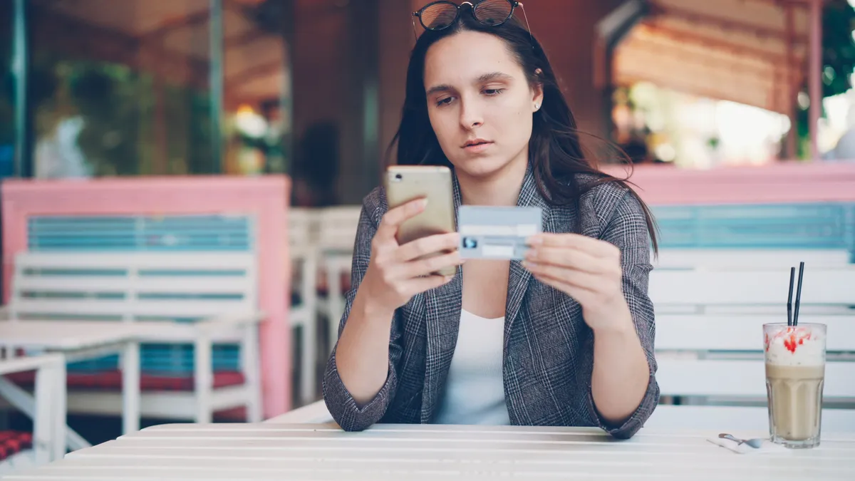 Woman making an on-time payment by phone to rebuild credit after bad credit personal loans